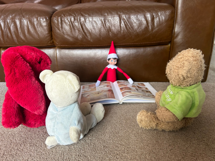 elf reading a Christmas story to other toys