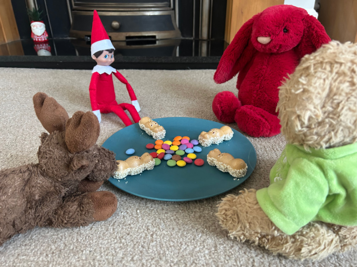 elf playing hungry hippos with toys and candy