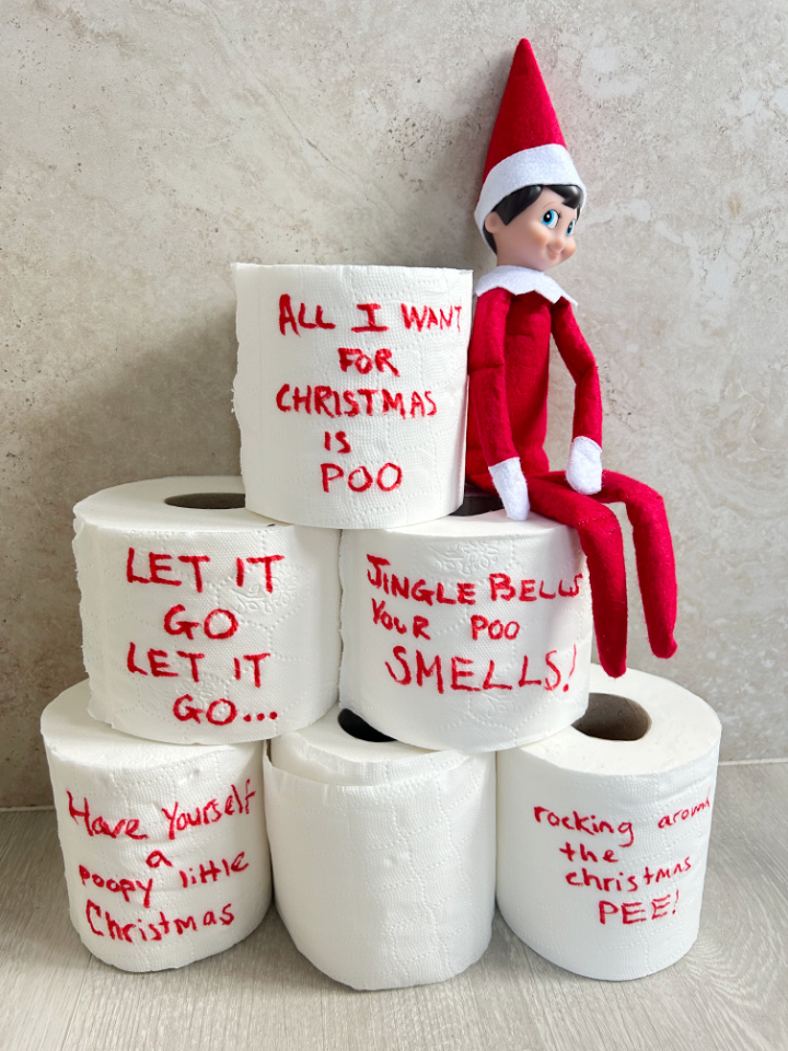elf decorating toilet rolls with Christmas jokes