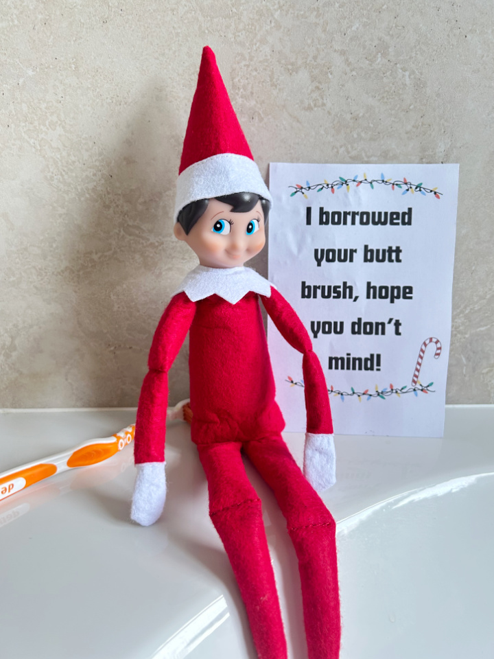 funny elf brushing his bottom with a toothbrush