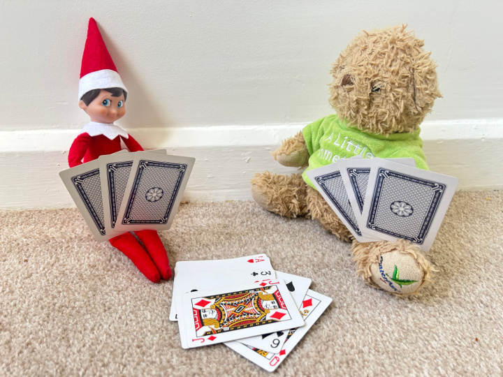 elf playing a card game with a teddy