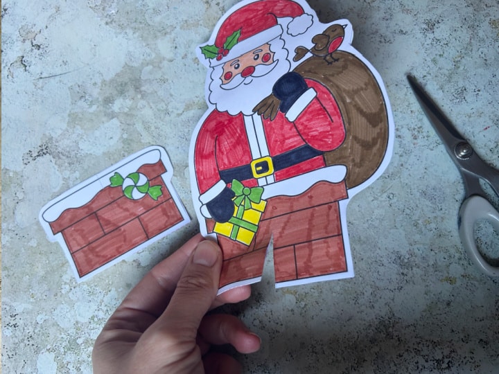 cutting slots in the Santa card pieces to create the 3D standing Christmas card