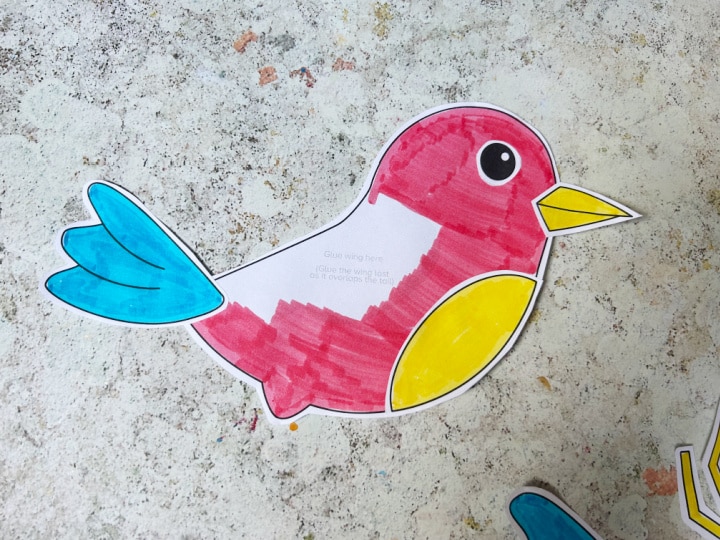 Assembling a cut and paste bird craft using glue