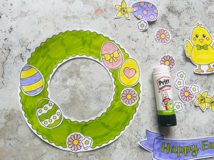 Gluing Easter decorations onto a wreath craft for kids