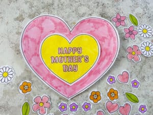 Gluing on heart shapes to make a Mother's Day craft