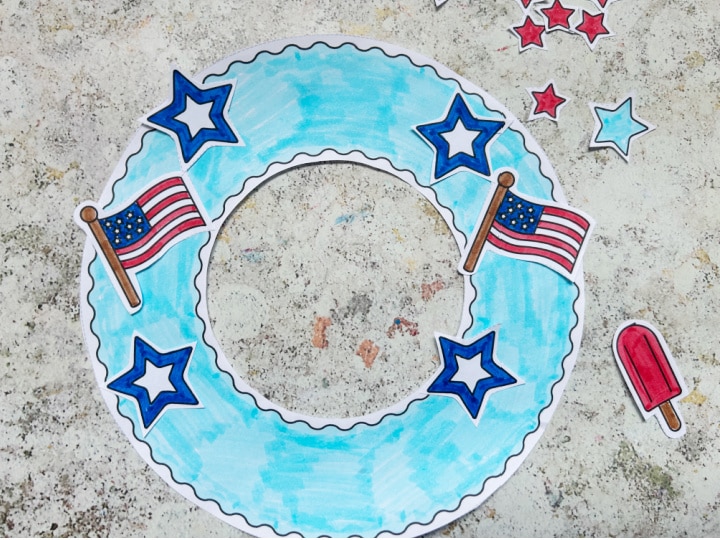 Adding patriotic decorations to a Fourth of July wreath craft