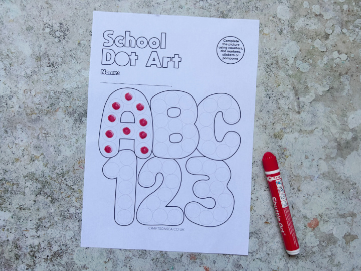 Alphabet and number dot marker printable being decorated with dot markers
