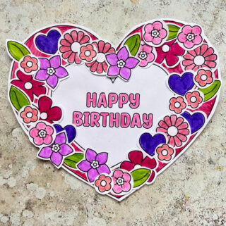 Printable birthday wreath craft made with a paper wreath and heart and flower decorations
