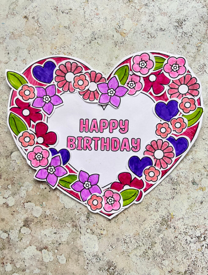 Printable birthday wreath craft made with a paper wreath and heart and flower decorations