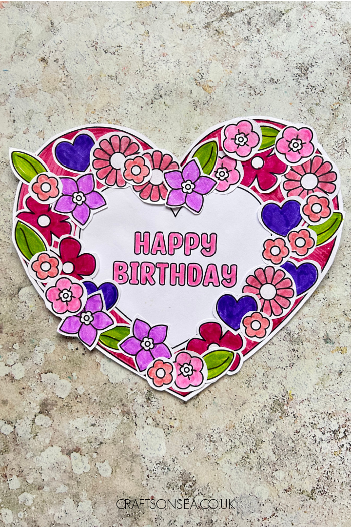 Printable birthday wreath craft made with a paper wreath and heart and flower decorations