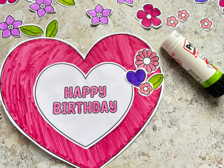 Gluing heart and flower decorations onto the birthday wreath