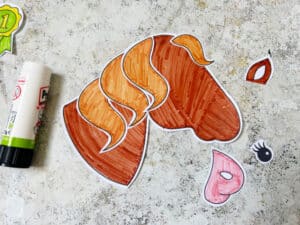 Gluing the mane onto a paper horse craft
