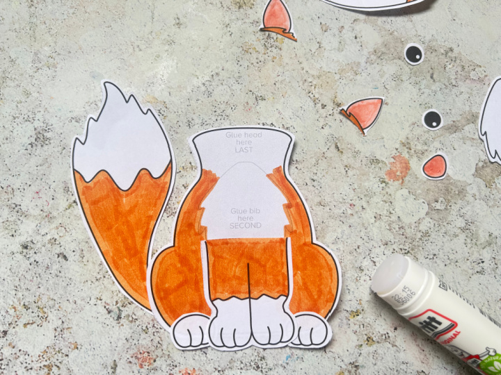 assembling a cut and paste fox craft gluing on legs