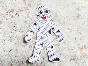 assembling halloween mummy craft stuck on eyes, mouth and head