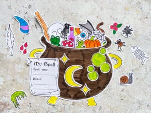 completed cauldron craft filled with spell ingredients including a paper frog, pumpkin and spider