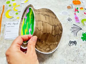 gluing a paper cauldron together to make a pocket