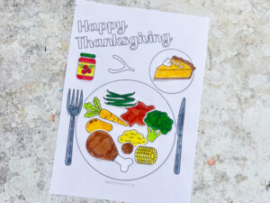 finished thanksgiving dinner craft showing all the food, sauce and cutlery glued onto the printable