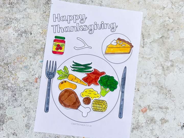 finished thanksgiving dinner craft showing all the food, sauce and cutlery glued onto the printable