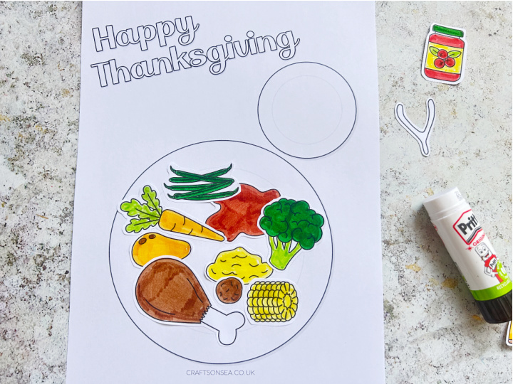 assembling the thanksgiving dinner craft by gluing food onto the plate